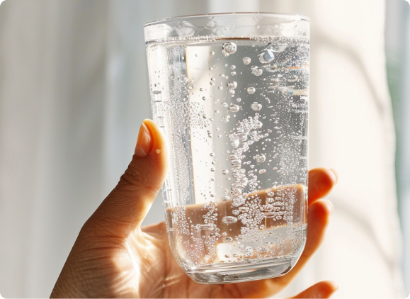 A saucepan on a stove with two pieces of chocolate inside.