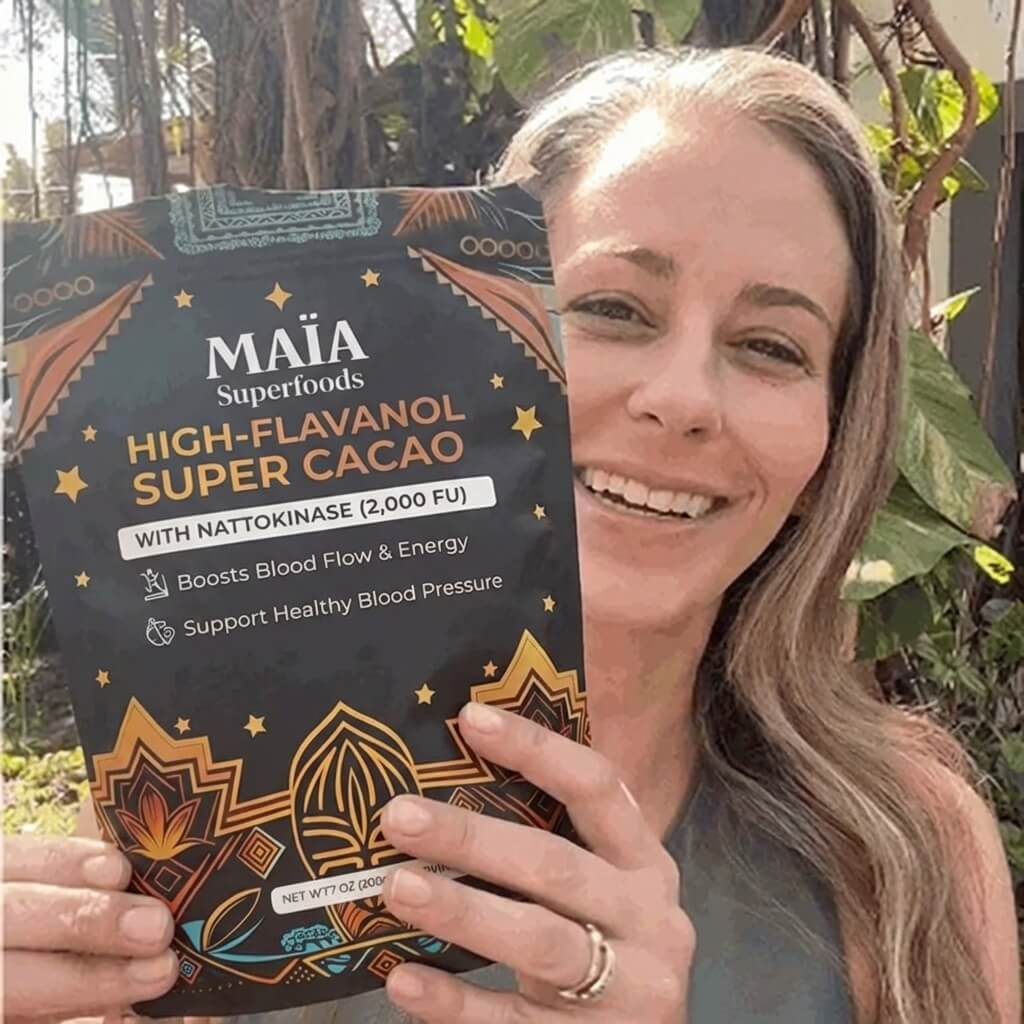 Woman holding a bag of Maïa ceremonial cacao with colorful design elements.