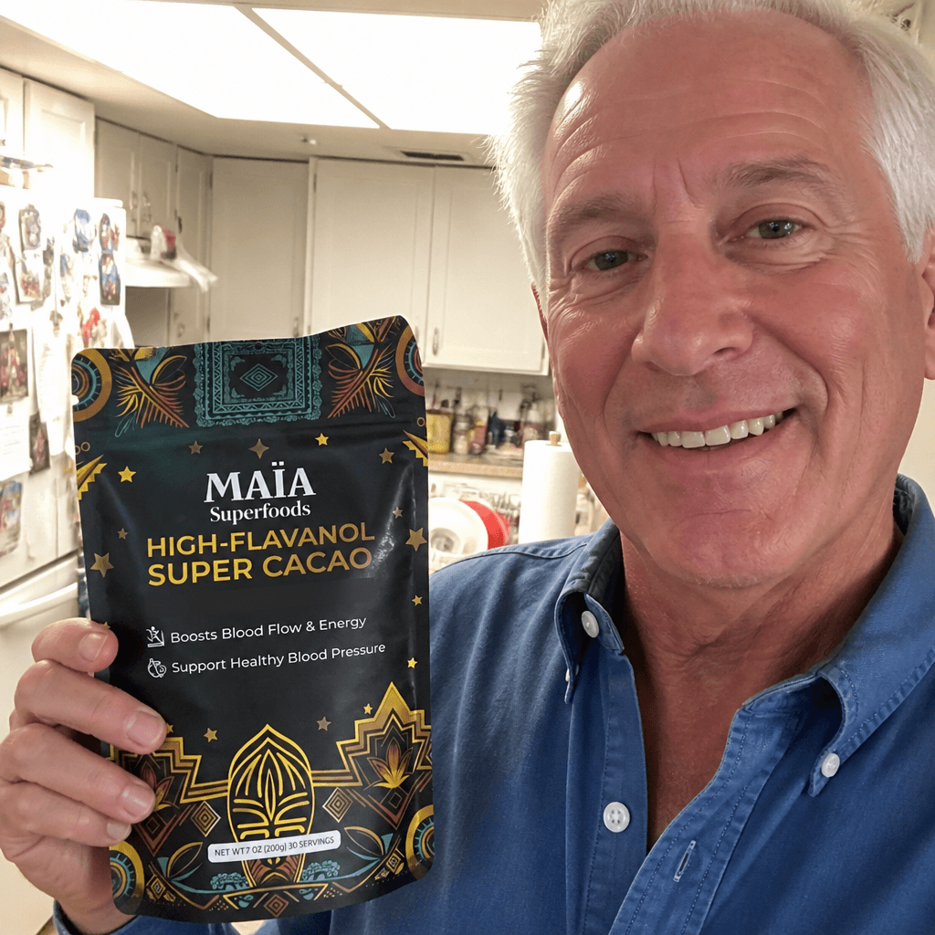 Man holding a bag of MAIA ceremonial cacao, smiling indoors.