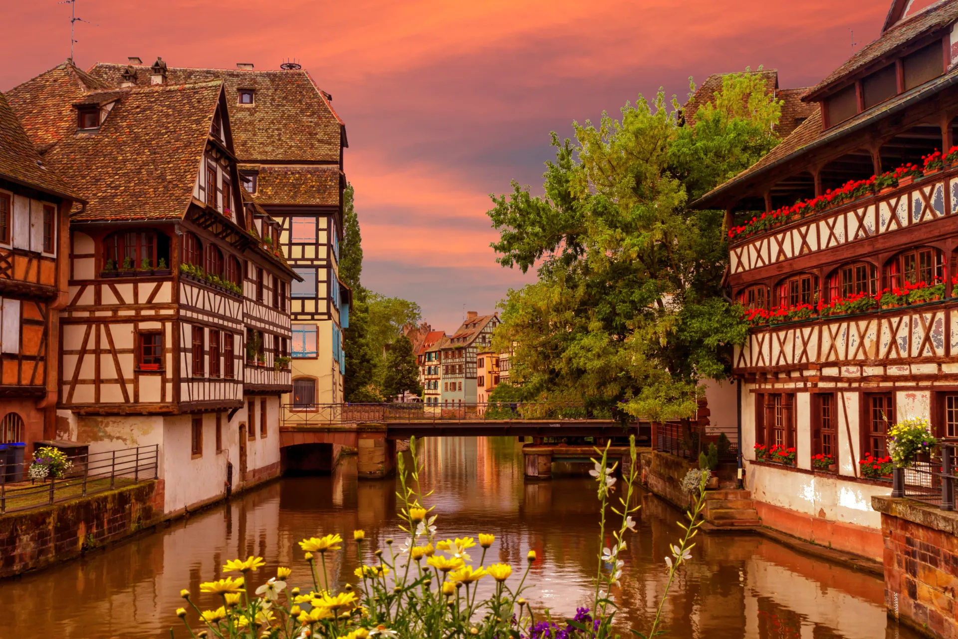 A canal lined with half-timbered houses at sunset in La Petite France, Strasbourg