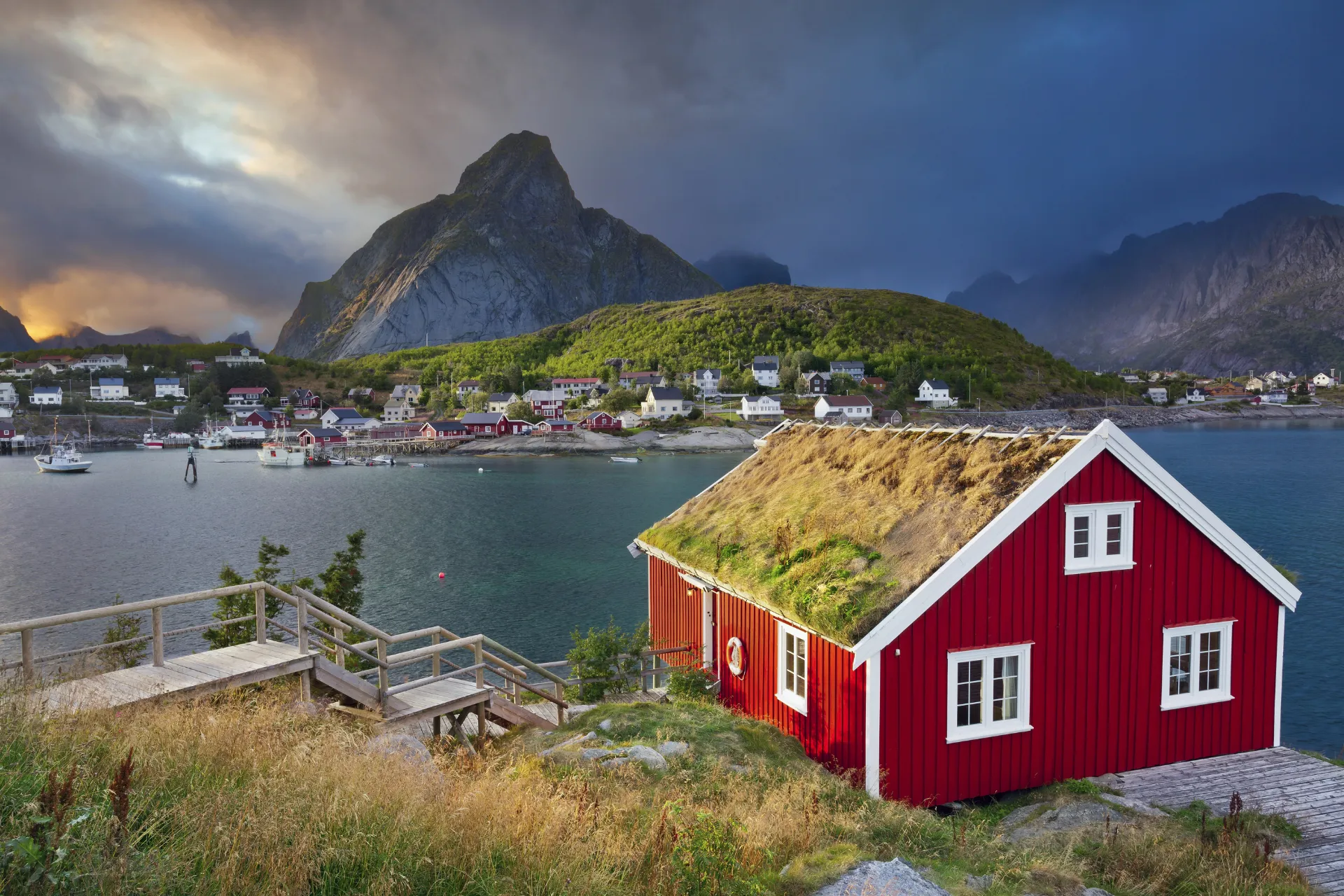 A Norwegian fjord village beneath steep mountains at sunset